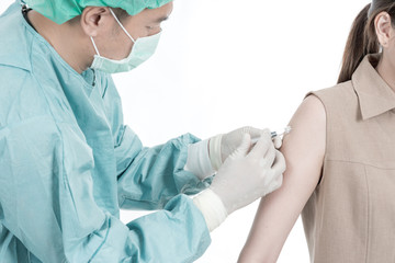 Health care concept. Chinese doctor providing medical injection to his patient isolated in white. Man in mid 40s with mask, hair cap, gloves, surgeon cloth.