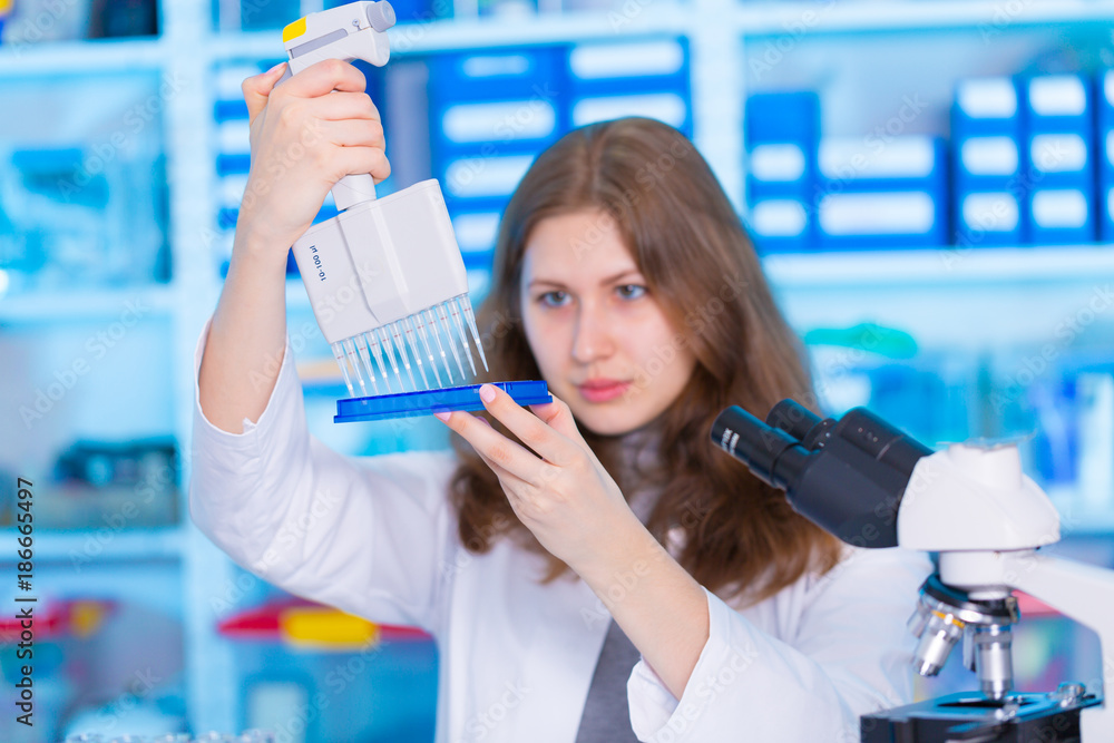 Wall mural laboratory female assistant with pipette