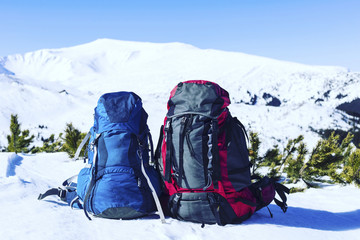 Winter hiking in the mountains on snowshoes with a backpack and tent.