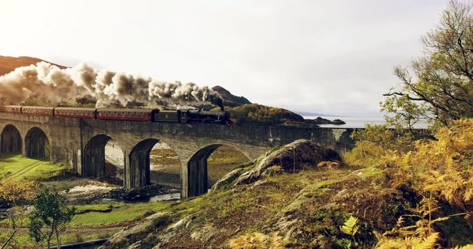 Aerial view of Steam Train crossing Glenfinnan Viaduct Scotland