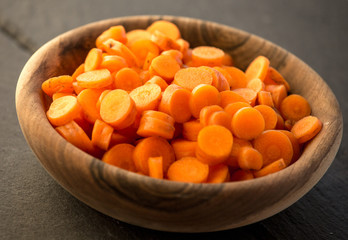 Chopped carrot in circles in wooden bowl