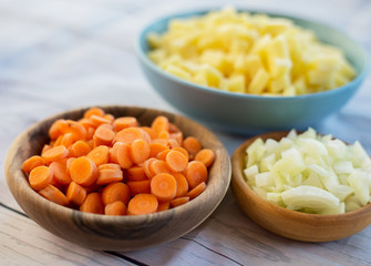 Top view of various vegetables cut in small pieces prepared for veggie soup cooking.