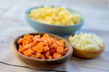 Top view of various vegetables cut in small pieces prepared for veggie soup cooking.