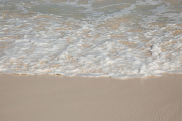Sand und Wasser. Meerwasser fliesst über den Sand.