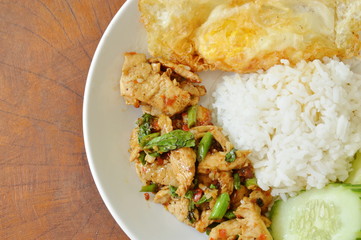 spicy stir fried chicken with basil leaf and egg on rice
