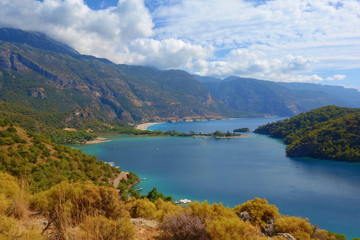 Obraz premium Amazing aerial view of Blue Lagoon in Oludeniz, Turkey. Summer landscape with mountains, green forest, azure water, sandy beach and blue sky in bright sunny day. Travel background. Top view. Nature