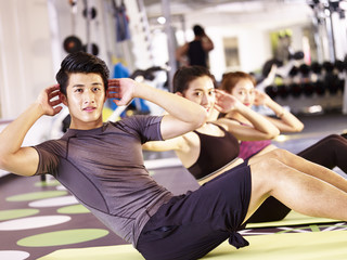 young asian people exercising in gym