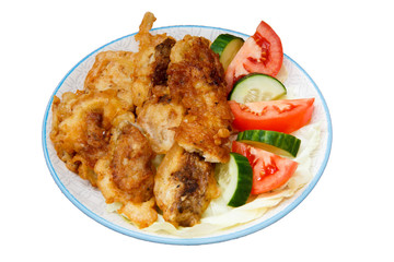 Plate with pieces of fried fish and freshly sliced tomatoes and cucumbers on isolated background