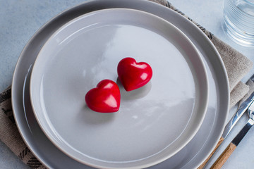 Valentine's day background table setting with two ceramic hearts on plate. Top view, copy space