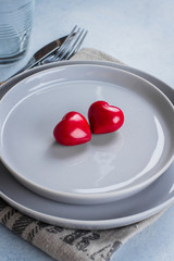 Valentine's day background table setting with two ceramic hearts on plate. Top view, copy space