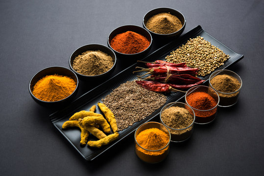 Indian colourful spices. Group photo of four basic Indian spices like raw red chilli, turmeric, coriander and cumin powder. selective focus
