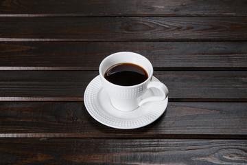 Mug of coffee on brown wooden background.