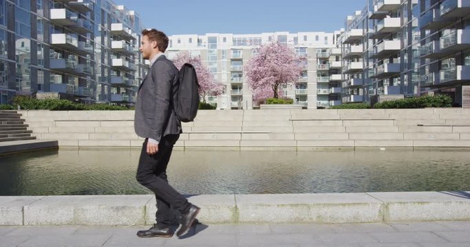 Businessman. Young Urban Professional Business Man Walking To Work By Modern Condos Wearing Backpack Wearing Backpack. Businessman In 30s In Copenhagen, Denmark, Scandinavia.