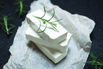 Organic goat cheese feta with rosemary on parchment paper.