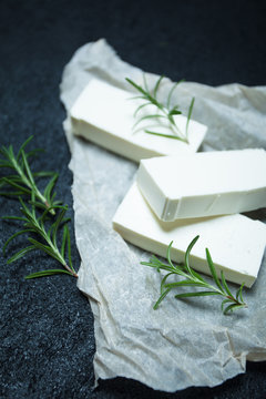 Greek feta cheese with rosemary in a rustic style on a black background.