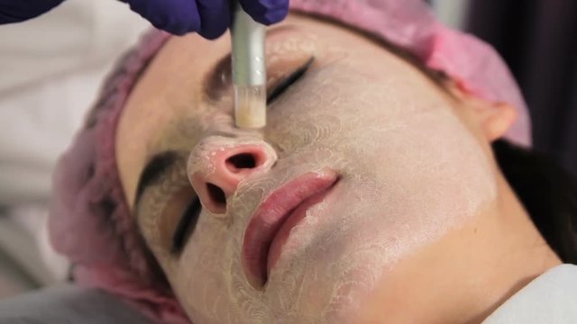 The woman on the procedure of lightening the skin. The patient's face in close-up. The appliance dermapen. Oriental medicine bbglow.