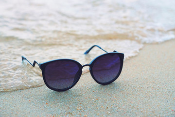 unglasses on the beach with beautiful blue sea in background
