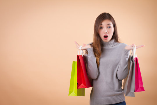 happy, excited woman shopper or customer with shopping bag