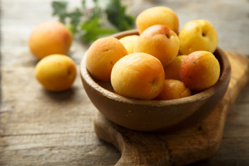 Fresh apricots in wooden bowl