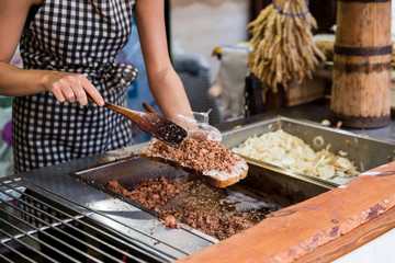 Woman cooking traditional polish declious food with bread with lard and fried onion. Street food fastival in center of old town in Gdansk,  city near baltic sea