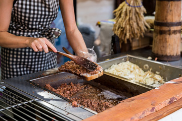 Woman cooking traditional polish declious food with bread with lard and fried onion. Street food fastival in center of old town in Gdansk,  city near baltic sea