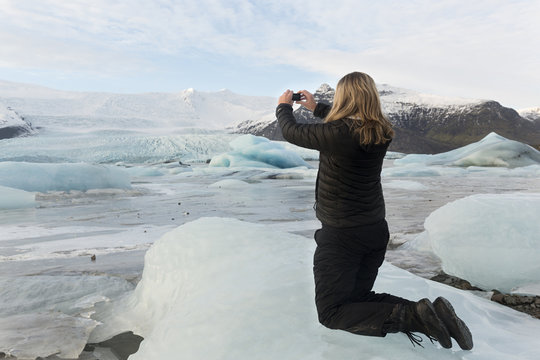 Mujer haciendo una foto en laguna glaciar de Fjallsárlón , Islandia