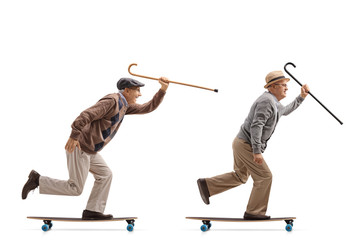 Two elderly men with canes riding longboards