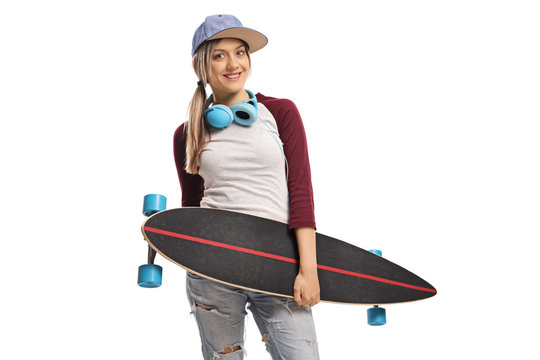 Female skater with a longboard and headphones smiling