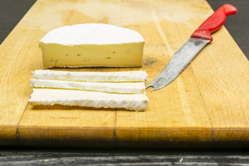 Camembert cheese on a chopping board.
