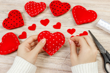 Woman creating red heart on wooden table. gift for St. Valentine's Day handmade