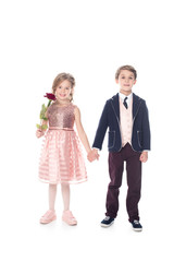 beautiful little kids holding hands and smiling at camera while girl holding rose flower isolated on white