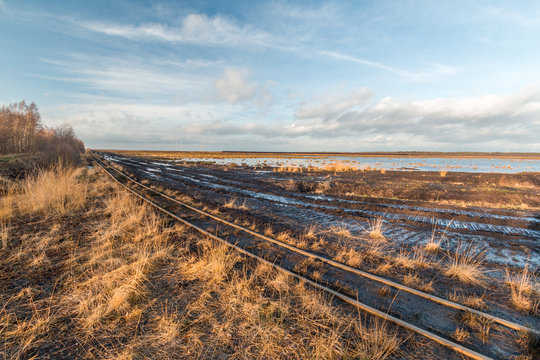 Landschaftsaufnahme eines Torfabbaugebietes mit Schienen einer Torfbahn