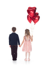 back view of cute little children with heart shaped balloons holding hands isolated on white