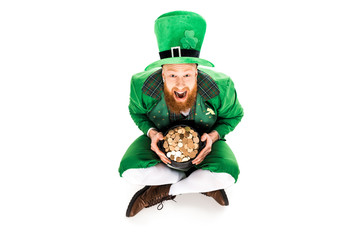 excited leprechaun in green suit holding pot of gold, isolated on white