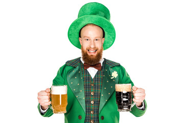 cheerful bearded man in green costume and hat holding glasses of beer and looking at camera...