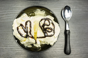 View from above. Vanilla ice cream scoops with chocolate glaze in a bowl.
