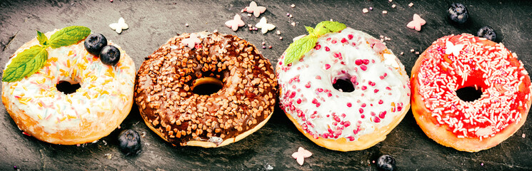 Donuts glazed with various sprinkles. Sweet food background