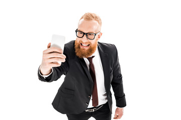 high angle view of young bearded businessman taking selfie with smartphone isolated on white