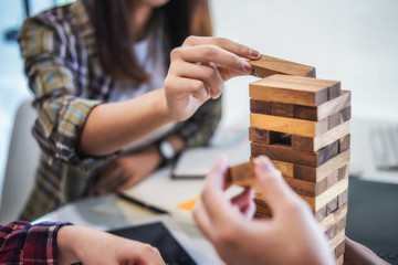 Team business hand's Plan and strategy in business, risk to make buiness growth with jenga wooden blocks.