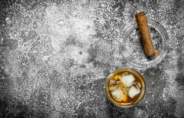 glass of whiskey with a cigar.