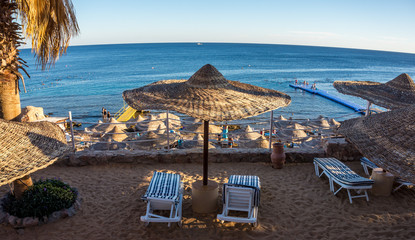 Beach and beach umbrellas. Coast of the Red Sea, Sharm el-Sheikh. Family holiday by the sea