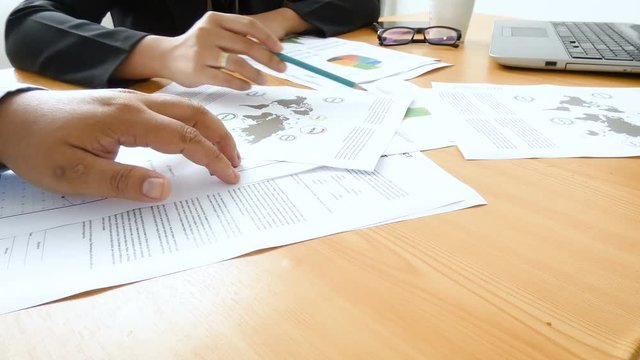 Business man and woman meeting and consult about business and marketing plan with infographic graph bar pi document on wooden table 