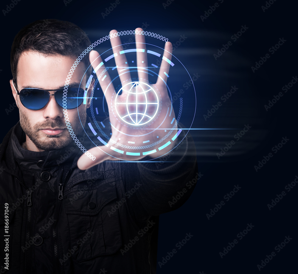 Wall mural man in sunglasses controls virtual system by hand.