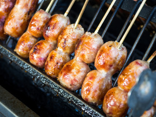 Thai sausage (Sai Krok Isan), made from mince pork, rice. Mix all together, stuffed in pork chitterlings,Thai sausage on the stove. Thailand street food