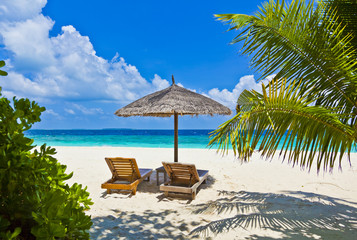 Maledivenstrand mit Sonnenschirm und Liegen
