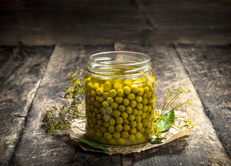 Pickled green peas in glass jar.