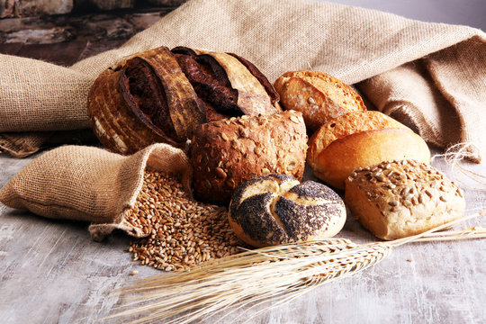 Different kinds of bread and bread rolls on board. Kitchen or bakery poster design.