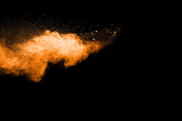 Fototapeta na wymiar abstract orange powder explosion on black background. abstract orange dust splattered on black background. Freeze motion of orange powder splash.