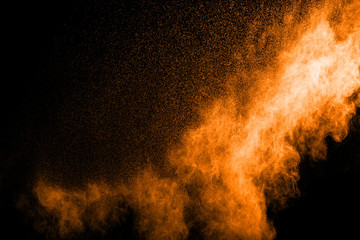 Fototapeta na wymiar abstract orange powder explosion on black background. abstract orange dust splattered on black background. Freeze motion of orange powder splash.