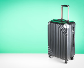 Plastic suitcase against green background